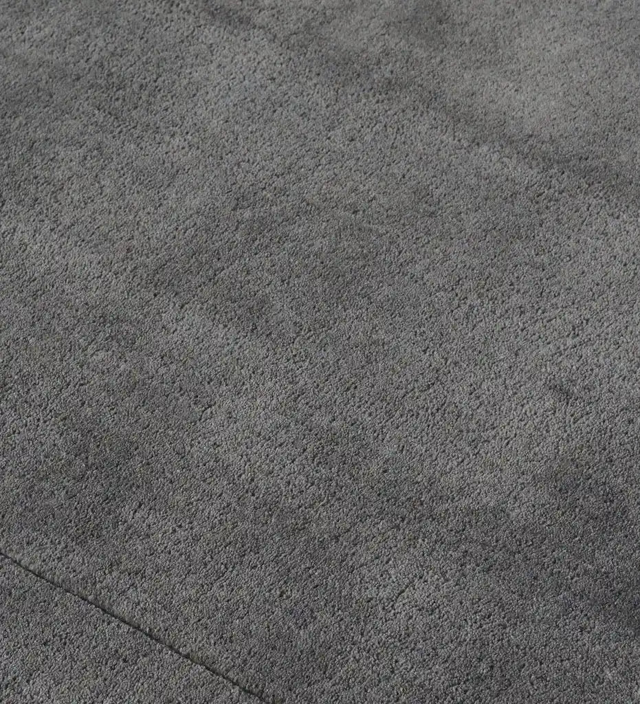 A close-up texture shot of a dark gray plush or short-pile fabric surface, showing the fine looped material detail.