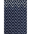 A rectangular area rug featuring a bold, repeating chevron pattern in navy blue, light gray, and white, shown flat against a white background.