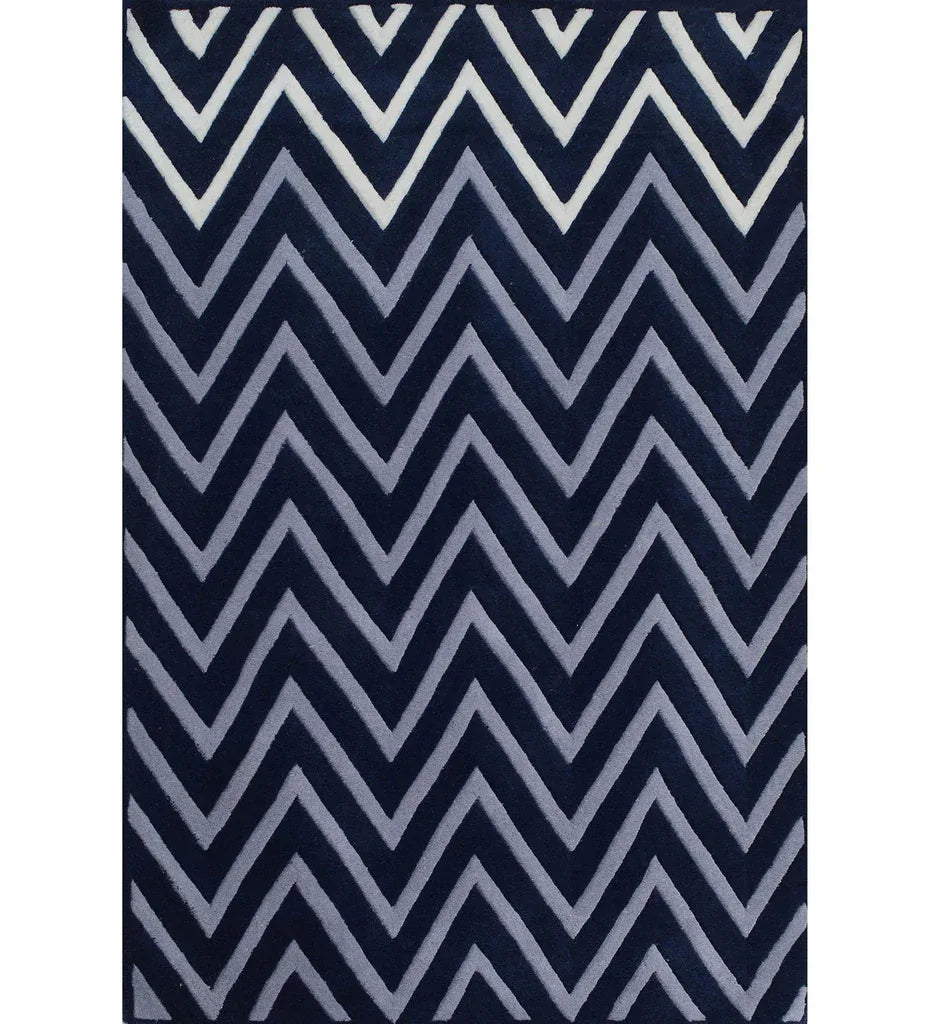 A rectangular area rug featuring a bold, repeating chevron pattern in navy blue, light gray, and white, shown flat against a white background.