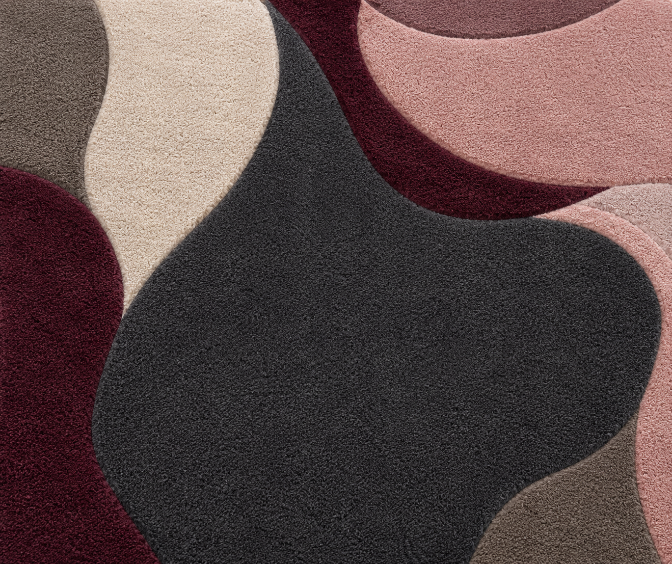Close-up of a textured rug with wavy patterns in brown, beige, and black.