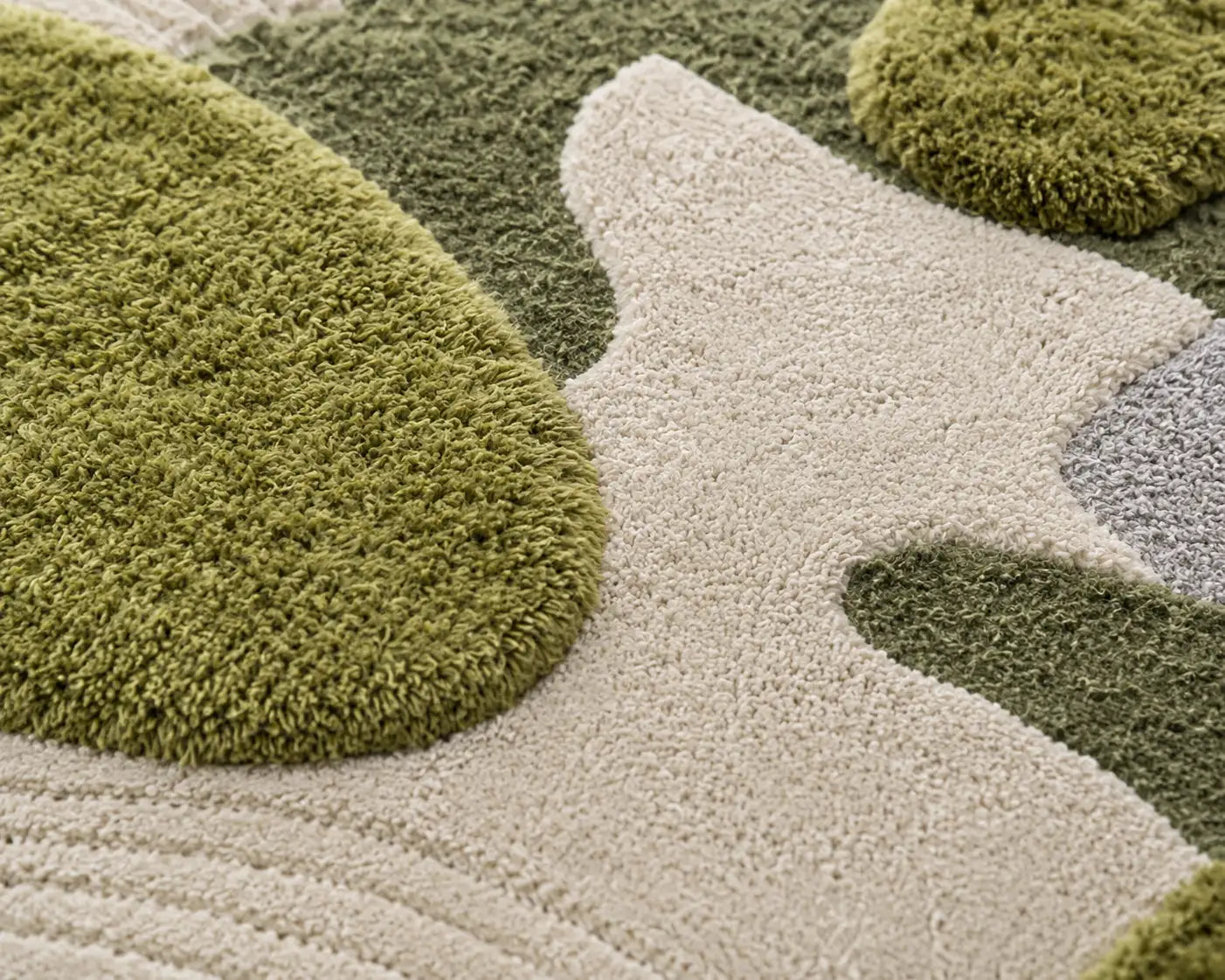Close-up of a textured rug with green and beige patterns