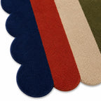 Four rectangular rug samples in navy, red, beige, and green on a white background