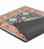 Orange and blue traditional hand-tufted rug with floral patterns and dark border, corner folded