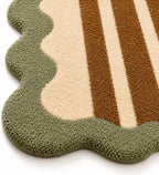 Textured rug with wavy edge and striped pattern in green, beige, and brown on a white background